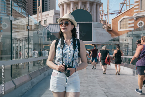 Photography smiling woman traveler in hat holding vintage camera in las vegas modern city usa