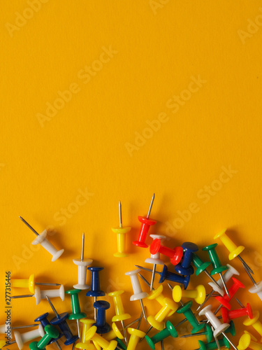 Colorful pushpins on yellow