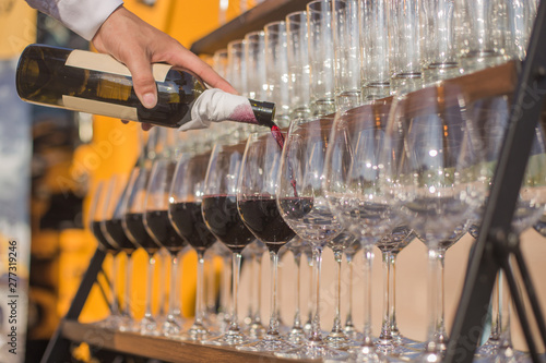 Wine. Sommelier fills wine glasses prepared for a party and tasting in honor of the harvest festival