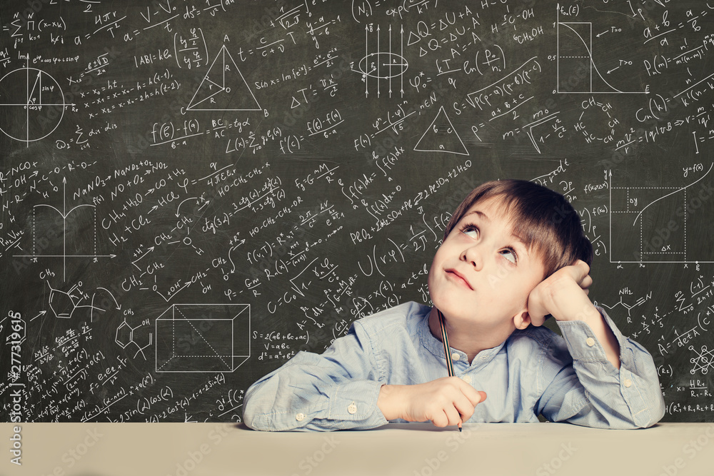 © artmim - Cute smart child student on blackboard background with science formulas. Learning science concept.