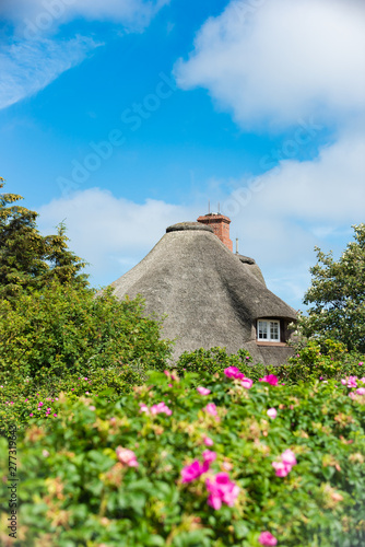 Typical house with straw roof in small village on Sylt island, Germany.