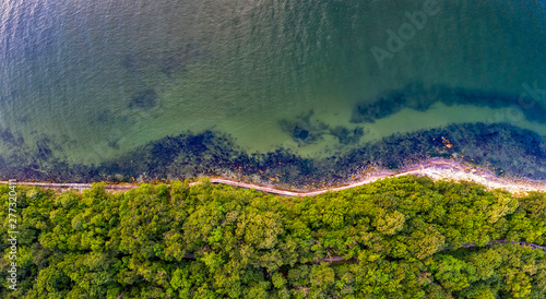 Fototapeta Naklejka Na Ścianę i Meble -  The coastline covered with green forest near the sea. Seawater surface in the lagoon. Varna, Bulgaria.