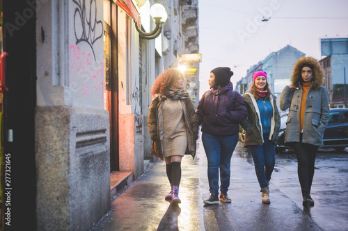 group of young women walking in the street and looking shop windows