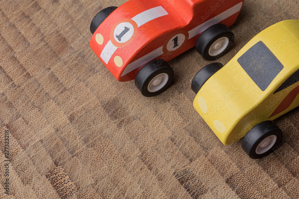 Fototapeta premium Yellow and red tony vintage toy cars racing on a wooden background