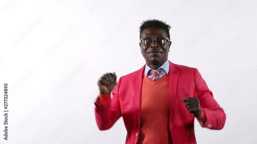 Waist-up shot of stylish middle aged African man in elegant red suit and eyeglasses smiling and dancing in studio against white background Waist-up shot of stylish middle aged African man in elegant red suit and eyeglasses smiling and dancing in studio against white background