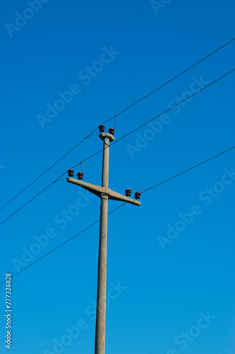 Concrete Wire Pole Against Blue Sky 