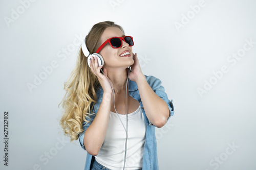 blond woman in headphones and sunglasses listening to music smiling white isolated background © studioprodakshn