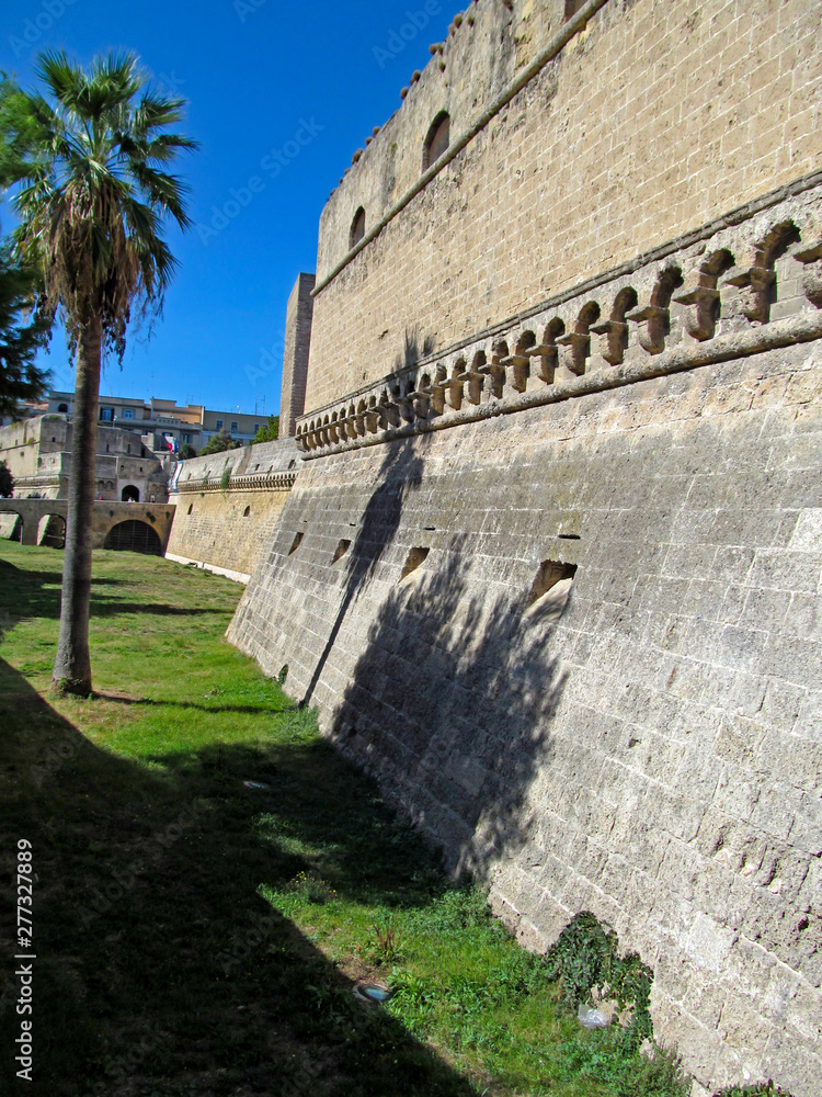 The Norman Castle in Bari, Italy. Italian name - Castello Normanno-Svevo. View of the medieval stone wall from the free street area.