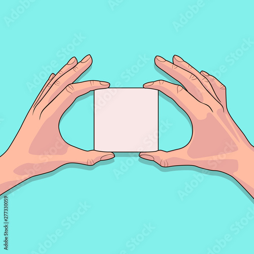 White piece of paper in the female hands on blue background. Blank sheet of paper