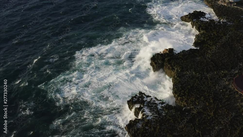 Aerial slow motion view of high ocean waves crashing at seashore cliffs. Bali island. Indonesia Aerial slow motion view of high ocean waves crashing at seashore cliffs. Bali island. Indonesia