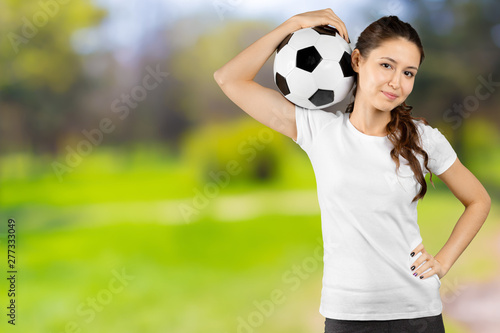 Soccer fan. Young beautiful woman holding soccer ball over isolated background © fotofabrika