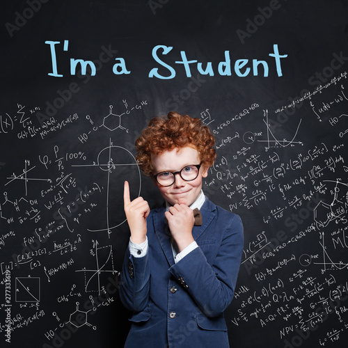 Smart child student in classroom on chalkboard background, Back to school concept