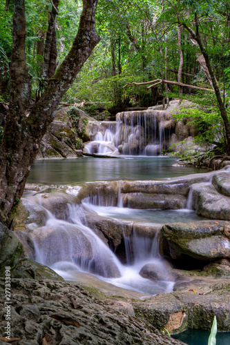 Fototapeta Naklejka Na Ścianę i Meble -  Clean green emerald water from the waterfall Surrounded by small trees - large trees,  green colour, Erawan waterfall, Kanchanaburi province, Thailand