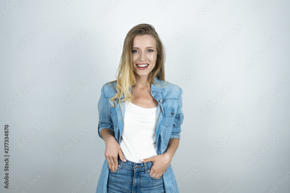 young beautiful woman with hands in her pockets smiling isolated white background young beautiful woman with hands in her pockets smiling isolated white background