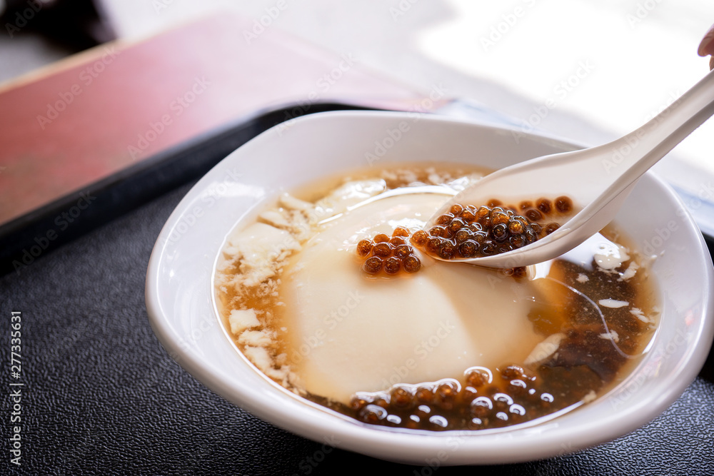 Popular Taiwan gourmet - Dessert of tapioca pearl ball (bubble) mixed bean curd tofu pudding (douhua, dou hua) in white bowl, close up, lifestyle Popular Taiwan gourmet - Dessert of tapioca pearl ball (bubble) mixed bean curd tofu pudding (douhua, dou hua) in white bowl, close up, lifestyle