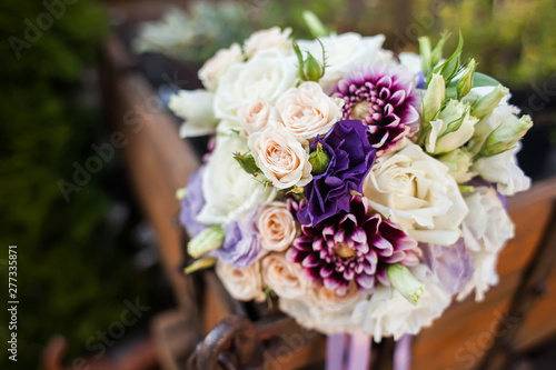 Wedding bouquet in purple tones on a wooden cart