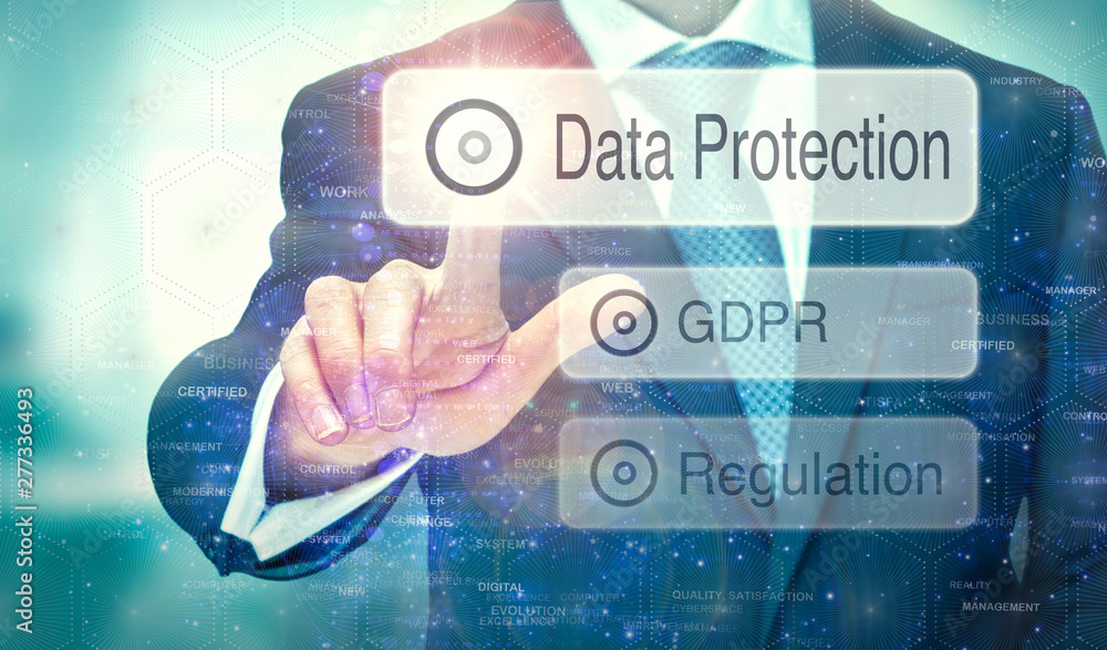 A businessman selecting a button on a futuristic display with a Data Protection concept written on it. A businessman selecting a button on a futuristic display with a Data Protection concept written on it.