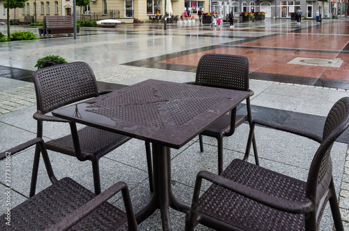 A CITY IN THE RAIN - Wet tables and cafe chairs on the town hall square