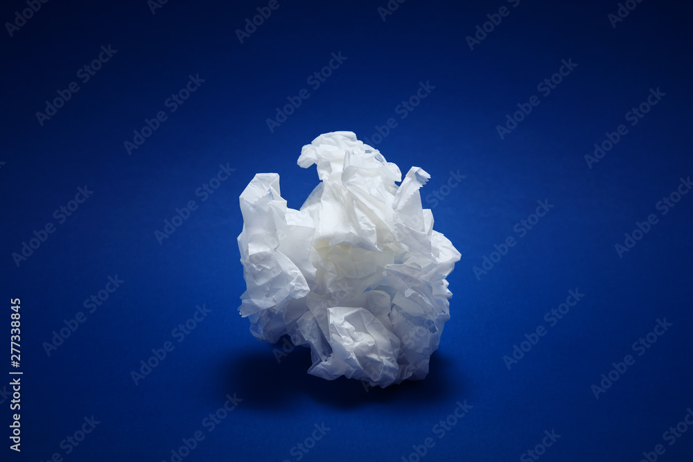 Crumpled white paper texture on blue background Crumpled white paper texture on blue background