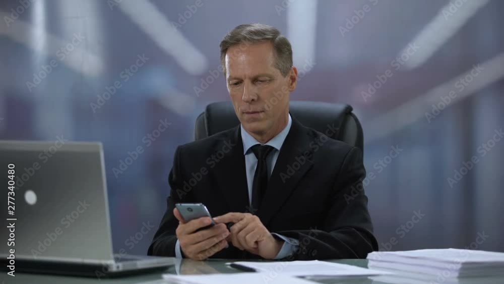 Businessman texting cellphone with client at workplace with laptop, technologies Businessman texting cellphone with client at workplace with laptop, technologies
