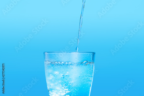 Close up pouring purified fresh drink water from the bottle on table