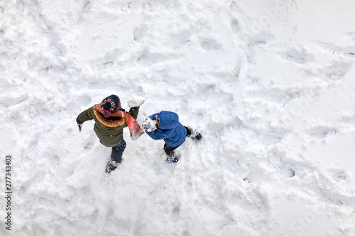 Aerial above view of two little children playing in the snow