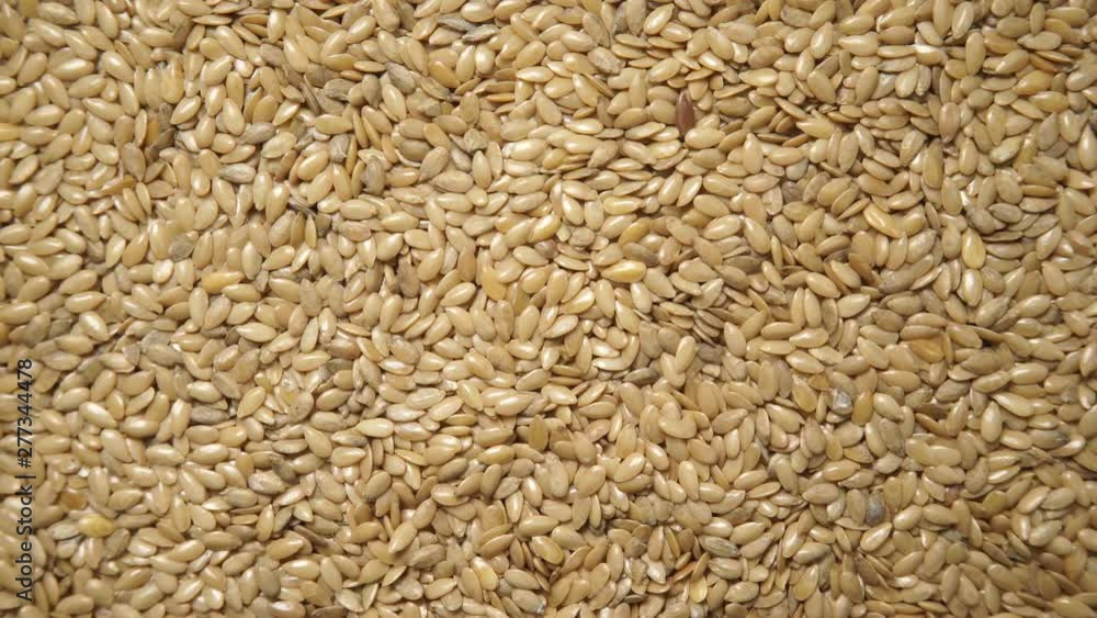 Golden raw flax seeds linseed as natural food background or grain texture. Flaxseeds full of omega 3 fatty acids. Top down view. Healthy diet organic nutrition Golden raw flax seeds linseed as natural food background or grain texture. Flaxseeds full of omega 3 fatty acids. Top down view. Healthy diet organic nutrition