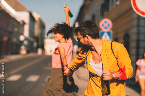 Young couple dancing on the street and holding two bottles of beer © djile