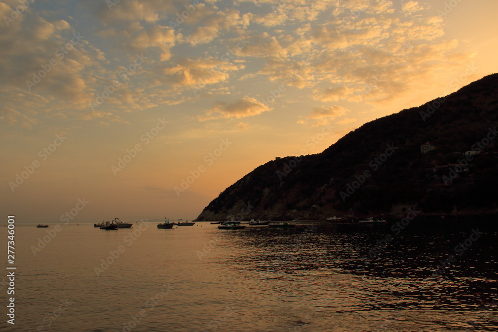 Costa all'Isola Elba al tramonto con nuvole chiare