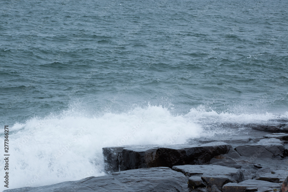 Fototapeta premium Waves of Lake Superior crashing on rocky shore