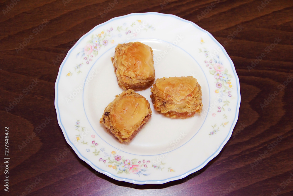 traditional Turkish puff sweetness baklava with nuts on white plate traditional Turkish puff sweetness baklava with nuts on white plate