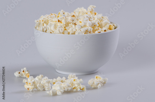 Full ceramic bowl of popcorn on white background