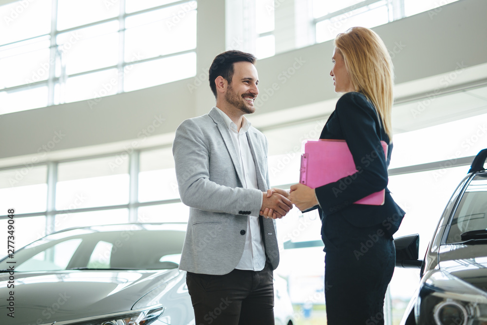 Dealer showing a new car model to the potential customer Dealer showing a new car model to the potential customer