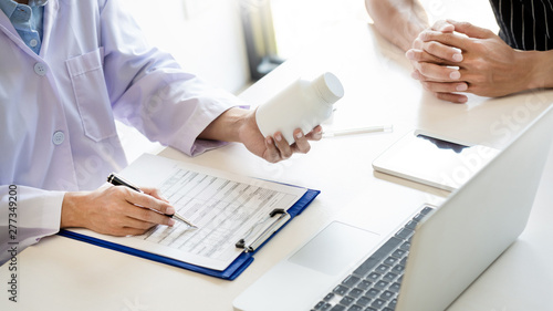 health care concept, doctor give a medicine bottle of drugs pills and explain the direction to use to patient in the hospital