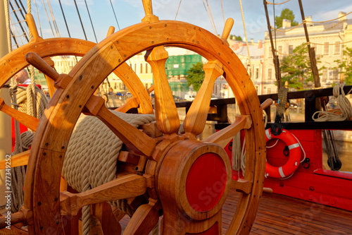 Helm wheel of an old wooden sailboat. Details of the deck of the ship