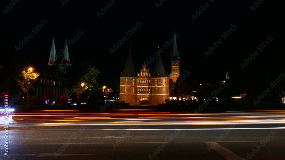 The famous Holsten Gate with night traffic blur in Lubeck, Germany