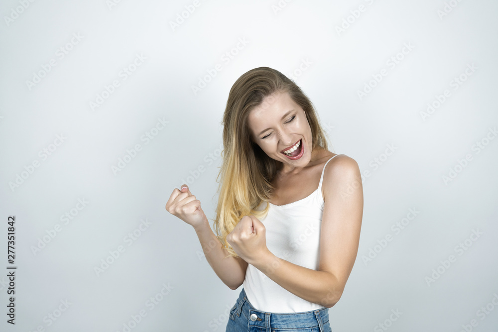 blond girl making a fist with both hands smiling isolated white background blond girl making a fist with both hands smiling isolated white background