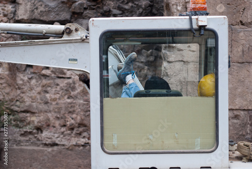 Worker sleeping in an excavator