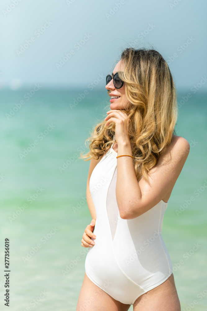 Woman at Dubai Beach. Summer sunny days. White swimsuits
