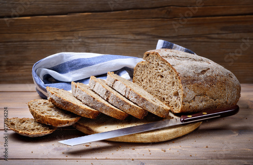 Freshly baked sliced bread on rustic wooden background