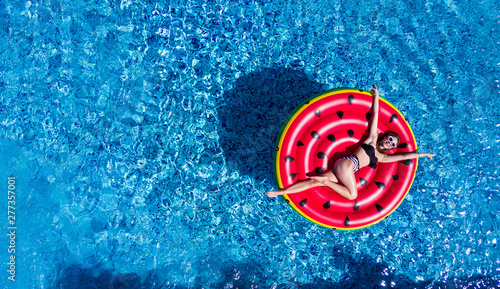 Canvas-taulu Top view of young woman relaxing on watermelon in pool