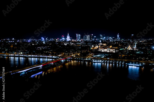 Night city skyline background. Aerial view of Warsaw capital city of Poland. From above, night city view with night sky. Night panorama of Warsaw cityscape. Aerial View © netsay