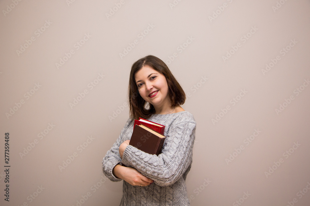 Fototapeta premium Portrait of young brunette woman with book in her hand