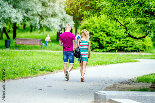 Fototapeta Naklejka Na Ścianę i Meble -  A guy and a girl walk along the path in the city Park 
