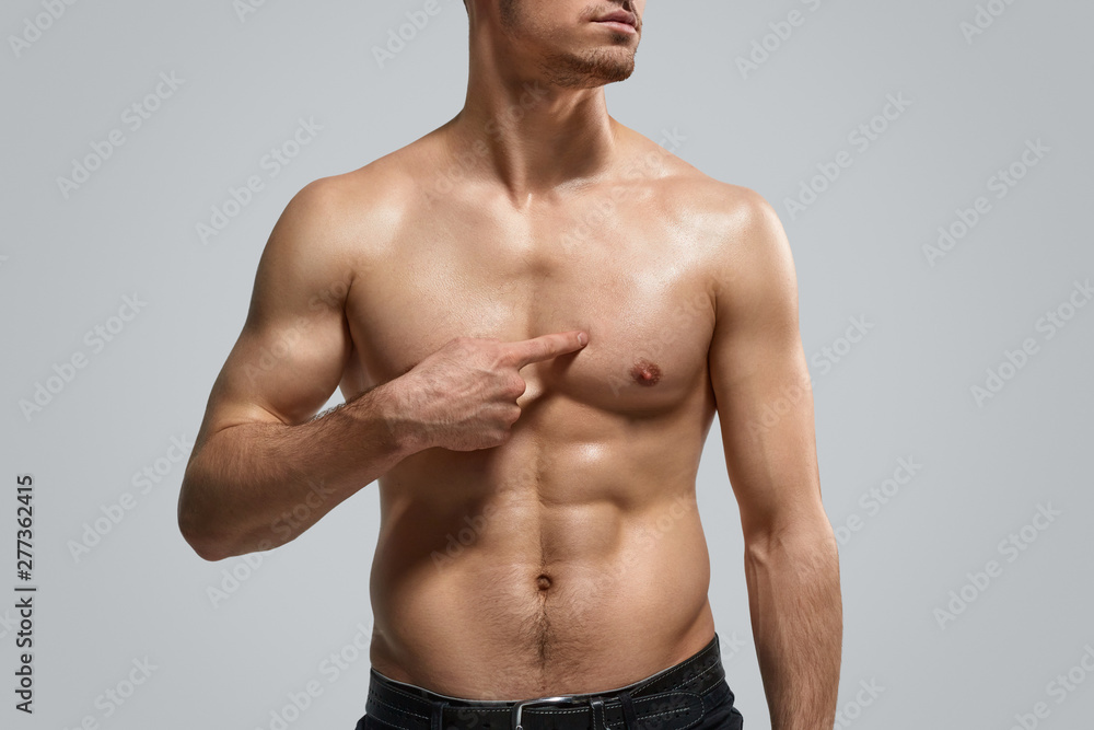Fototapeta premium Crop guy pointing at muscular chest