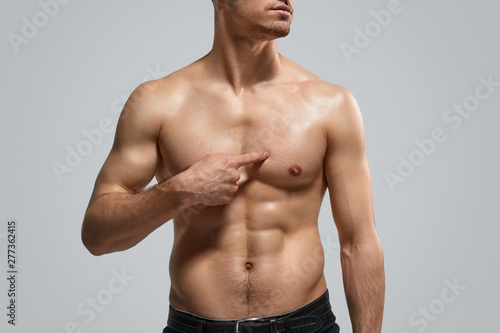 Crop guy pointing at muscular chest photo