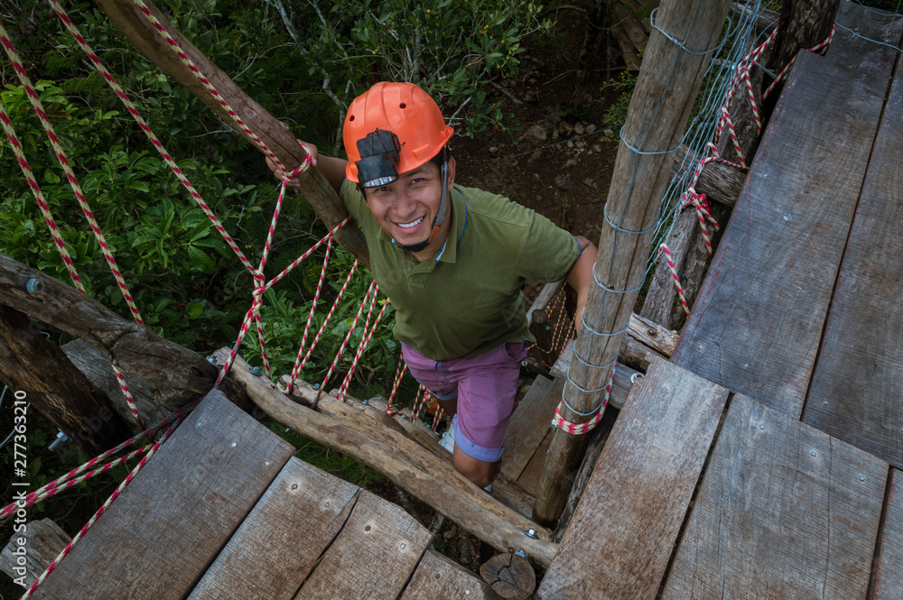 Hombre subiendo escaleras para llegar a la cima del mirador en excursión. Hombre feliz con casco naranja para excursiones. Hombre trabajando con casco de seguridad. Hombre subiendo escaleras para llegar a la cima del mirador en excursión. Hombre feliz con casco naranja para excursiones. Hombre trabajando con casco de seguridad.