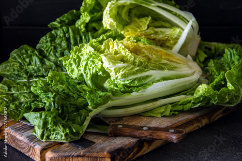 Fresh Chinese cabbage in a cut on a dark wooden background. Diet proper nutrition. Vegetables and fruits. Dark Food Photography