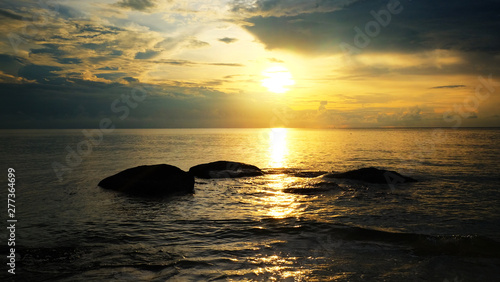 Sand beach with reef and sunrise sky on the morning.