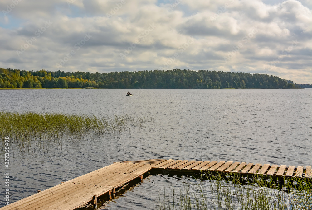 Fototapeta premium Fishermen on the lake with fishing rods fishing on an autumn day.